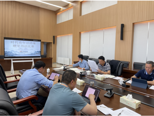 1653558350392347.png 圖為:評委認真評選參賽的廉潔書法作品.png